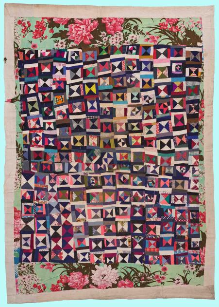 A quilt composed of multicolored triangles and squares.