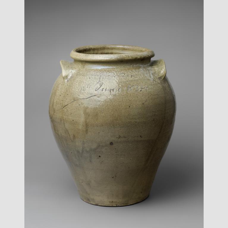 A large, greenish clay jug with a large opening, two handles, and imprinted with the test "12th June 1834."