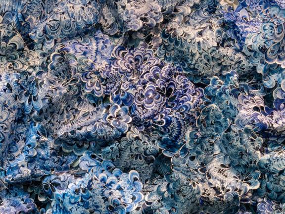 Blue-and-white shell-like pieces of plastic interlocked to resemble a wave. 