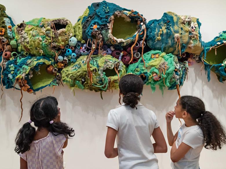 Three young visitors view the exhibition Community Arts Initiative: From Farm to Craft Table