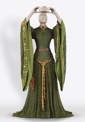 A mannequin wears a green dress with wide sleeves and golden belt. 