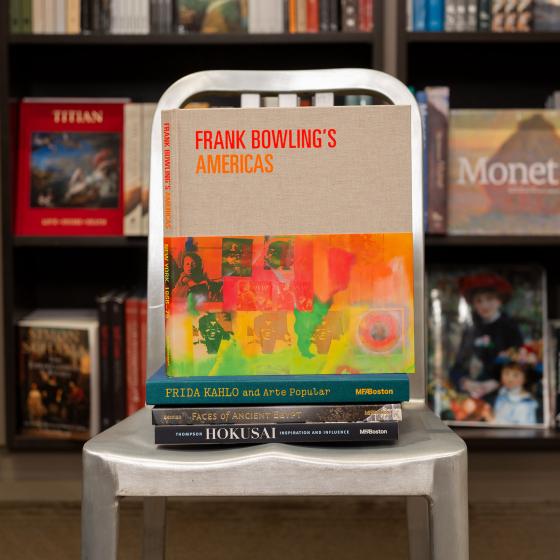 A stack of MFA publications, topped by "Frank Bowling's Americas" sit on a chair in the MFA Shop