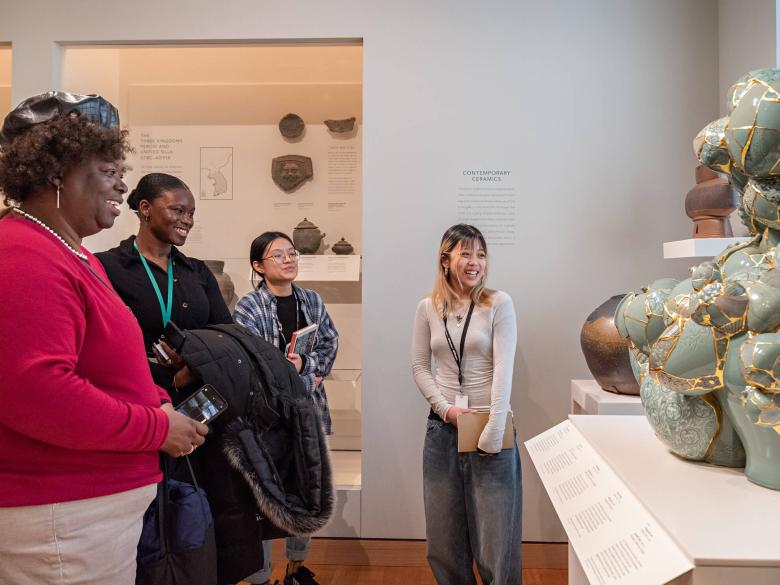 Four visitors looking at contemporary ceramic vessels seemingly made from broken ceramic fragments