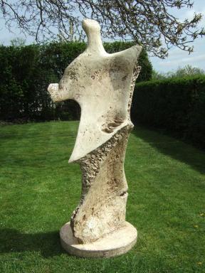 An abstract fiberglass sculpture in a green garden.