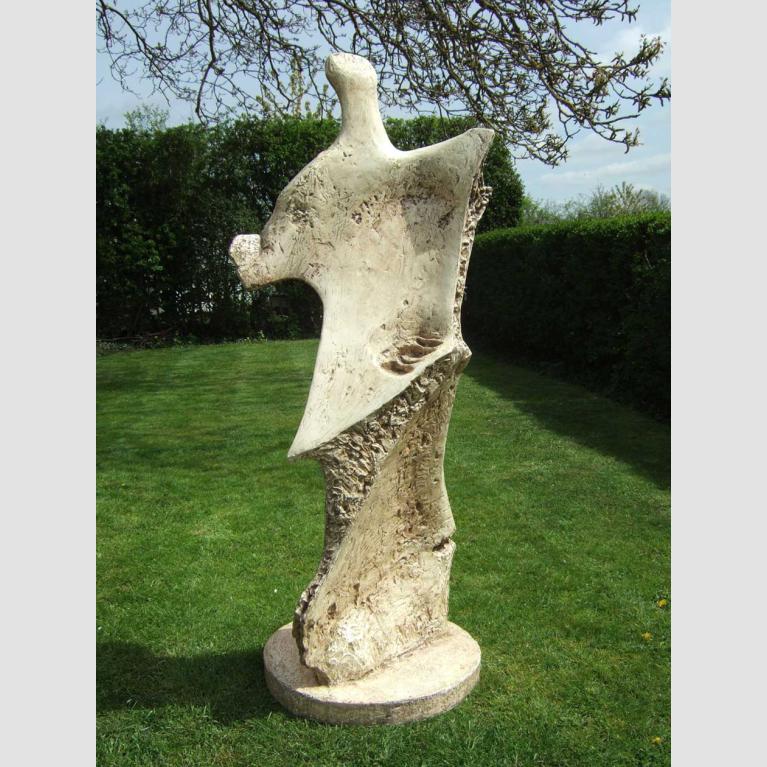 An abstract fiberglass sculpture in a green garden.