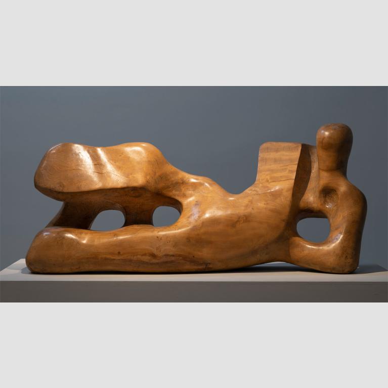 Wooden sculpture that abstractly resembles a reclining figure