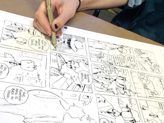 Teen student drawing comic strip in class (SAC)