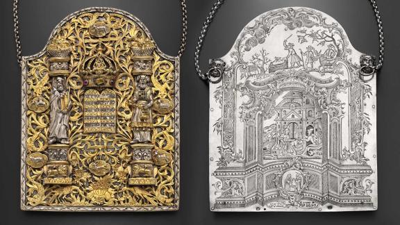 A composite image of the golden front and silver back of an ornate and intricately-detailed Torah shield inlaid with stones.