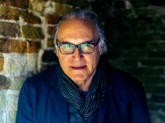 Artist Alan Michelson wearing glasses and a blue jacket 